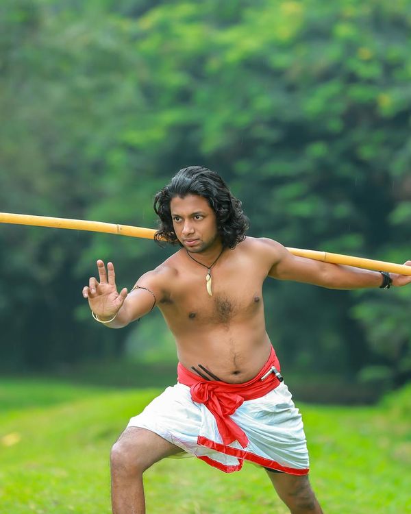 Man performing a controlled strength exercise in a dark, focused environment.